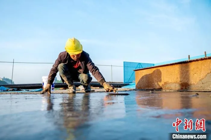 浇筑完成后一名工人师傅正在进行收面作业。　刘忠俊 摄