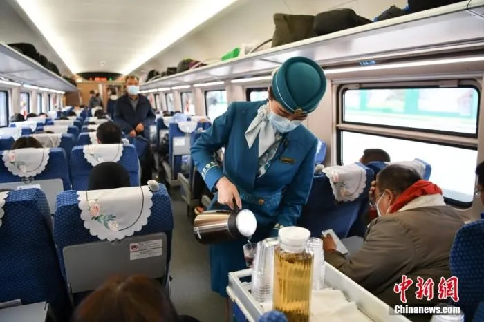 中老铁路全线开通运营。图为列车员为旅客提供服务。 中新社记者 刘冉阳 摄