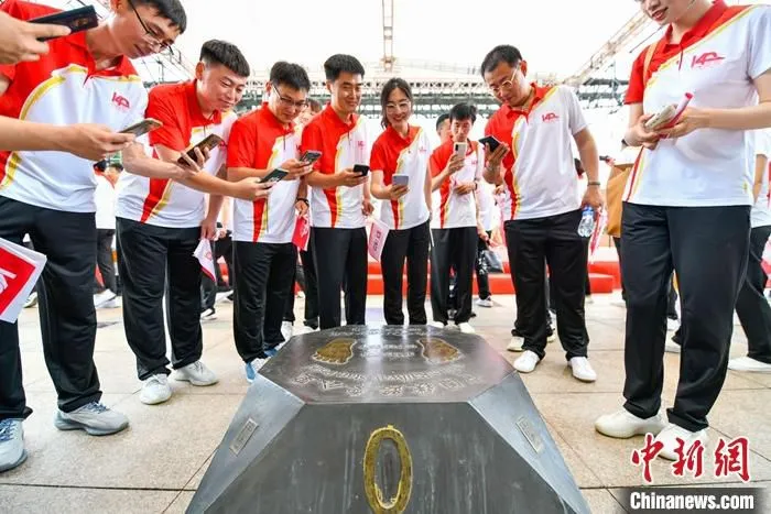 图为中国中车员工在“中国铁路零公里”标识旁拍照留念。 中新社发 　赵亮 摄