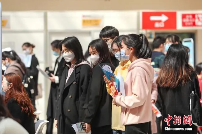 资料图：几位大学生在排队等待面试。 刘力鑫 摄