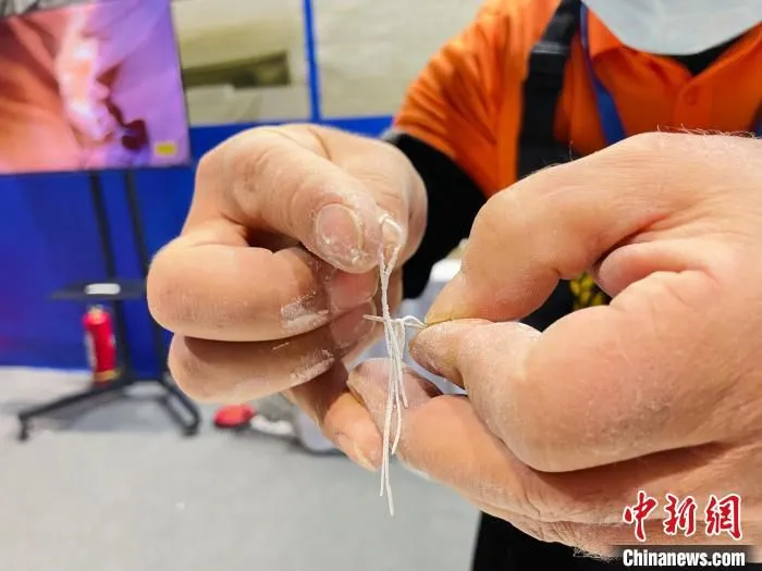 图为冶文祥在展示“拉面穿针”。　王琳娜 摄