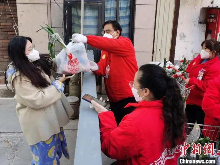 西安市莲湖区一小区门口，超市工作人员正在为民众送菜。　党田野 摄