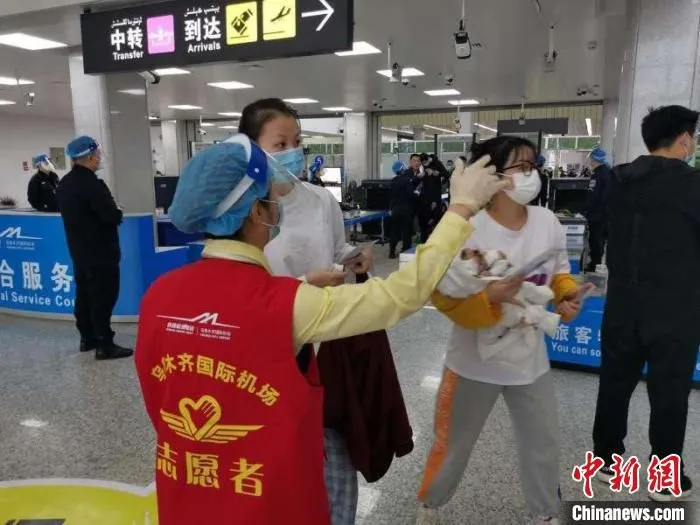 乌鲁木齐国际机场志愿者为旅客服务。　新疆机场集团提供。