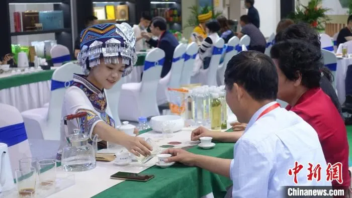 身穿民族服饰的茶艺师为茶商斟茶。　钱晨菲 摄