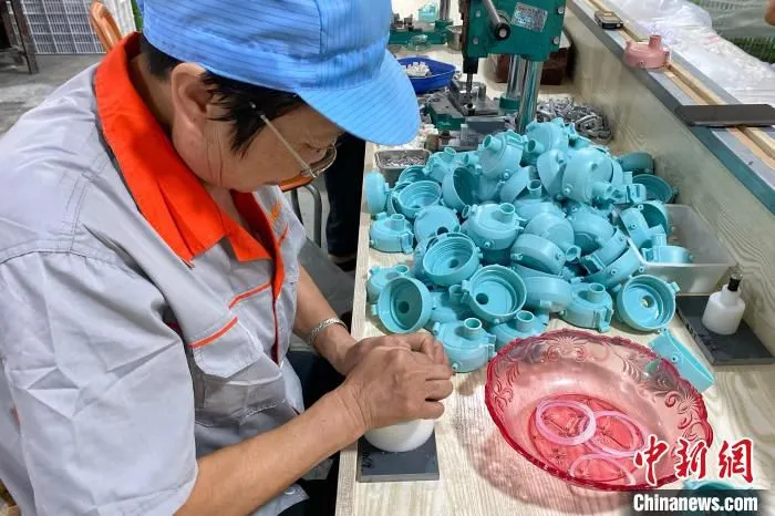村民组装瓶盖。　钱晨菲 摄