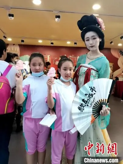 小朋友举着老雪糕与唐服美女合影。　赵桂华 摄