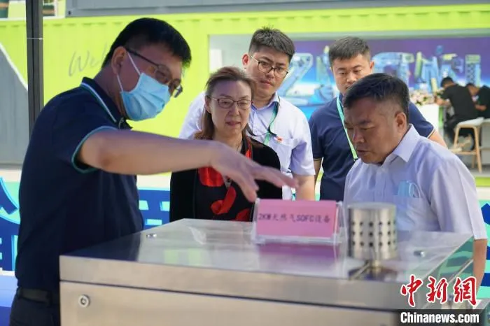 清华大学燃料电池与储能研究中心主任韩敏芳(中)等专家向来宾介绍氢燃料电池工作原理。　潘旭临 摄