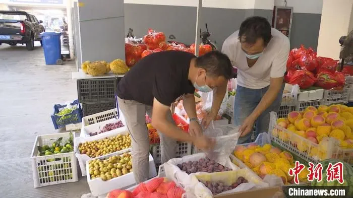 戴国红为客户挑选水果。　毛武瑛 摄