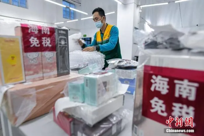 中国邮政集团公司海口市分公司的工作人员正在打包需要“邮寄送达”服务的海南离岛免税品。
中新社记者 骆云飞 摄