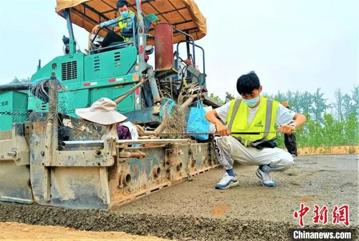 技术员正在对路水稳层铺设厚度进行测量。　睢宁县委宣传部供图