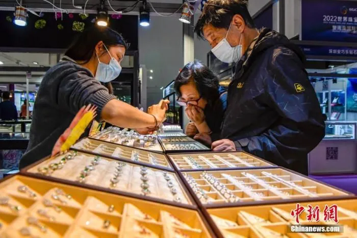 图为海口市民在海南国际珠宝展选购饰品。 中新社记者 骆云飞 摄 　