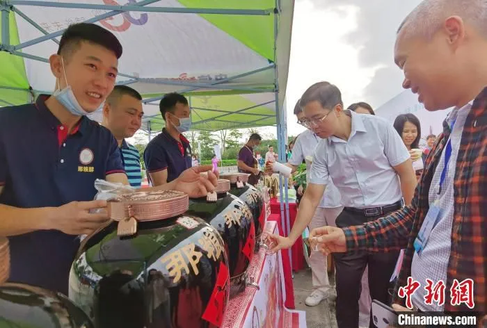 图为参会人员品尝特色美食。　黄秋艳 摄