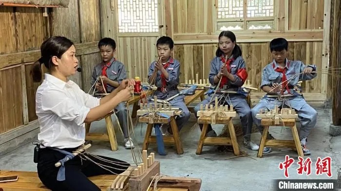 学生在红色研学基地学习草鞋编织。　钱晨菲 摄