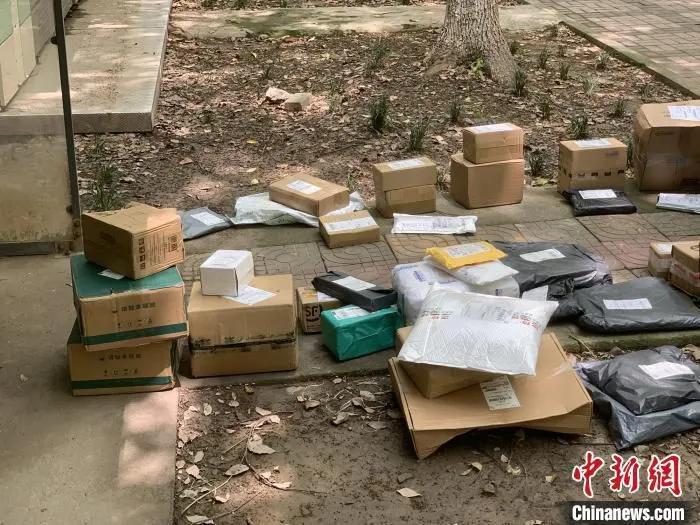 资料图：地面上摆放的是快递小哥待投放入快递柜的快递包裹。　康玉湛 摄