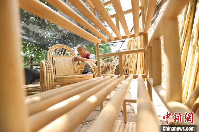 图为廊坊市安次区调河头镇南马庄村一蜡杆加工厂，工人正在制作蜡杆逍遥椅。　贾珺 摄