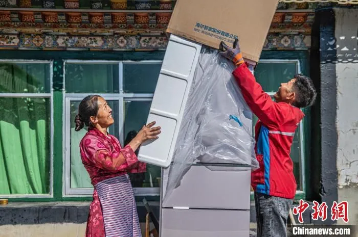 图为京东配送员给定日县城消费者提供大件家电送货上门服务。　刘畅 摄