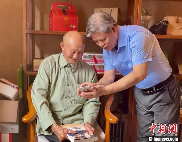 中新社福建分社社长徐德金(右)与黄振芳老人交谈。　吕巧琴 摄