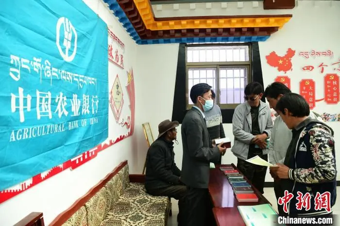 图为农行日土县支行工作人员在甲岗村进行金融政策宣讲。　贡嘎来松 摄