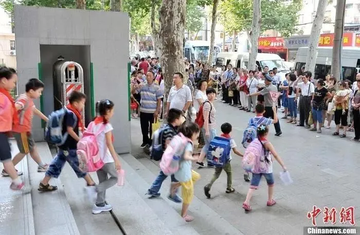 资料图：小学门外等待学生放学的家长们。中新社发 张畅 摄