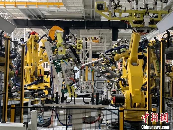 在位于江西上饶的一家新能源电动汽车公司的智慧工厂内，412台宛如“变形金刚”的机器人正同时作业。　李韵涵 摄