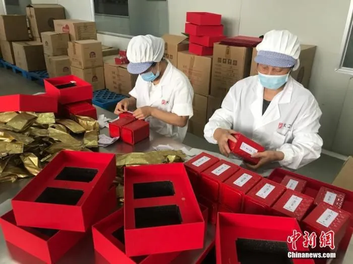 9月3日，安徽省祁门县一祁红制作车间，工人们在封装祁红。中新社发 潘成 摄