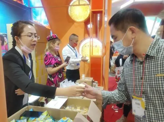 前来的天津市民品尝美味的新疆特产 古丽阿亚提 摄