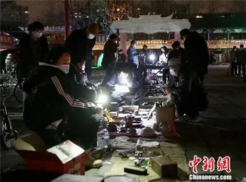 4月2日晚，在“鬼市”买卖旧货的人们。中新社易海菲 摄