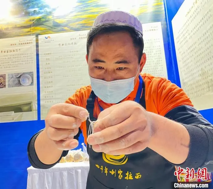 图为冶文祥在展示“拉面穿针”。　王琳娜 摄