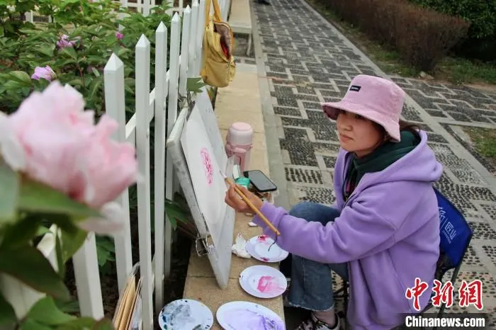 绘画爱好者在花间写生，用画笔留住牡丹花的美丽倩影。　　赵晓 摄