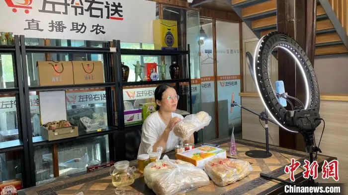 村民在家门口直播卖土特产。　钱晨菲 摄