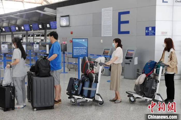 旅客正在等候区内等待办理登机手续。　殷立勤 摄