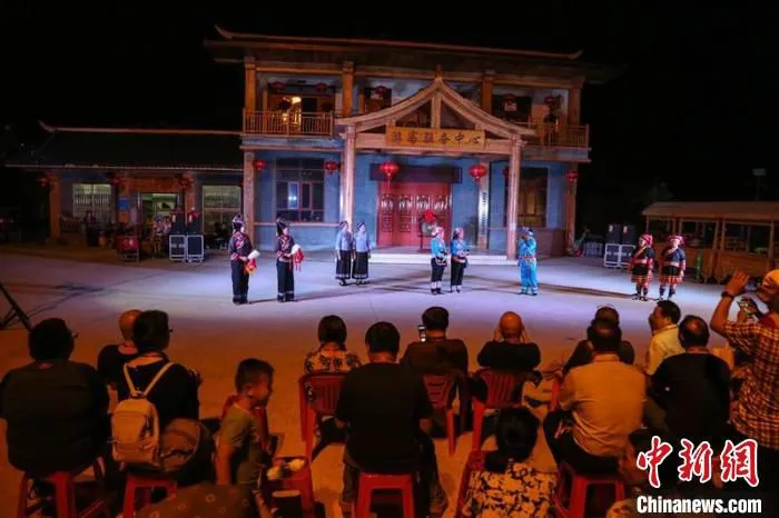 图为游客晚间观看民族文化表演 祝明贵 摄 图为游客晚间观看民族文化表演 祝明贵 摄
