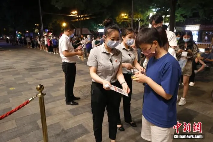 6月6日零时，食客在北京东直门内大街一餐厅外扫码、测温后进入餐厅用餐。 中新社记者 富田 摄