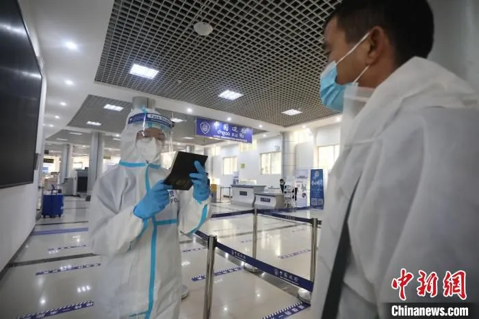 图为民警对旅客进行认证复核。　磨憨边检站供图 摄