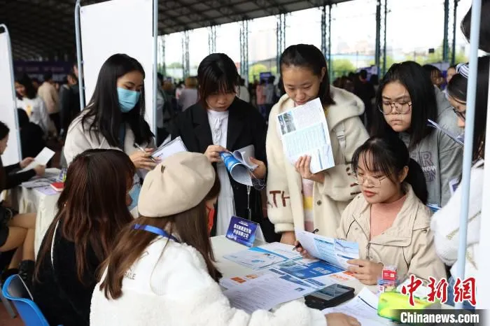 图为重庆举行现场招聘会，求职者询问岗位信息。　重庆人社供图