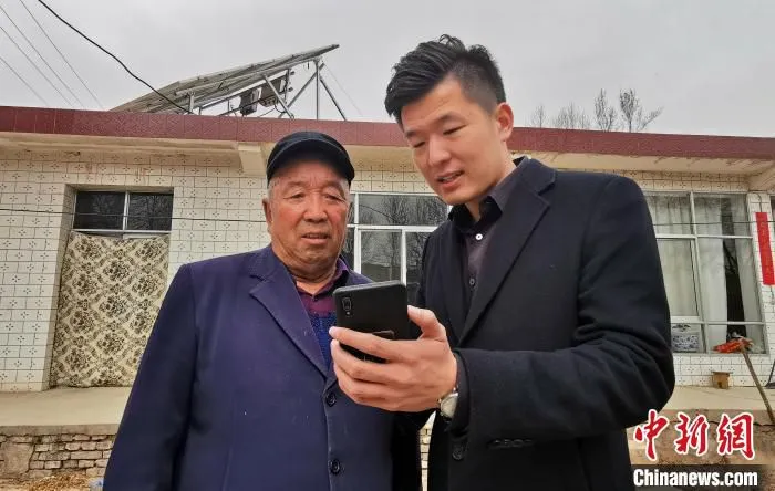 图为工作人员知道村民李生明使用智慧能源管理平台。　颜金梅 摄
