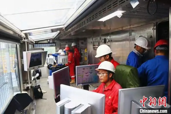 川东钻探公司员工正在操作边钻边建立根系统。　周密 摄