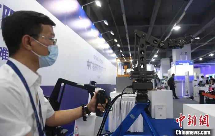 工作人员展示可远程模拟操控的机械抓手 王刚 摄