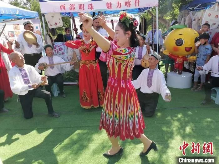 赛杏会展销区，英吉沙民间艺人跳起民间舞庆祝盛会。　朱景朝 摄