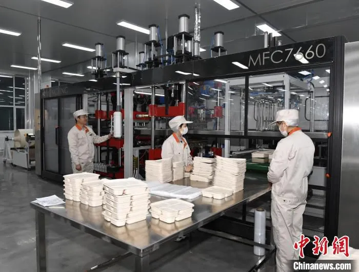 一条条自动化流水上，以玉米淀粉为原材料的环保餐盒经过压模成型被生产出来。　郑村镇供图