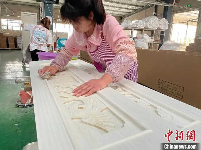 图为，庄寨镇一工厂工人正在加工棺木。　孙宏瑗　摄