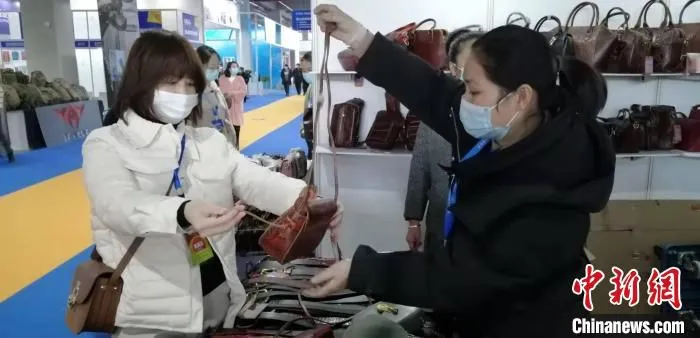 一位女士正在选购包包。　严万达 摄