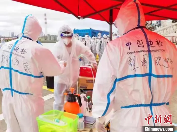 边检民警身着防护服，手持边检智能查验终端，稳妥快速为66名海员和12名旅客“一站式”办结了入境手续。　外高桥边检站供图