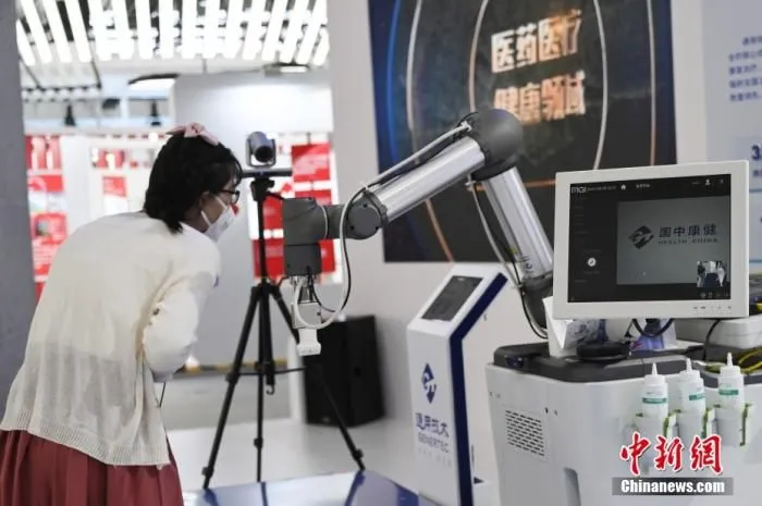 一款5G远程超声诊疗设备吸引参观者。中新社记者 张兴龙 摄
