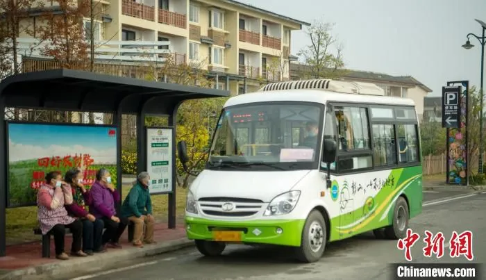 村民在站台等公交车。　刘忠俊 摄