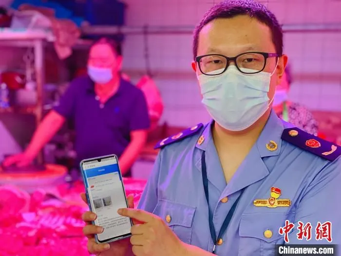 宁波市市场监管部门执法人员在检查动物产品在“浙食链”系统上的追溯信息。　宁波市市场监管局供图