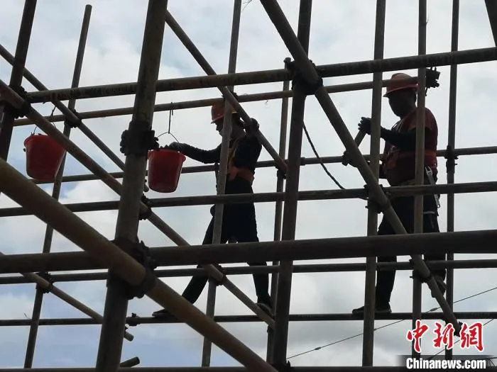 图为施工人员在紧张施工。　张伟明 摄