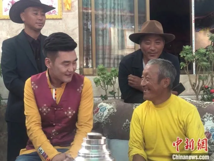 达瓦(前排右一)和村民们在自己家的民俗中。 中新网 左宇坤 摄