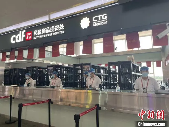 中免集团免税商品提货处，员工均佩戴防疫护具。　中免集团海口美兰机场免税店供图