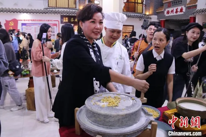 明星主播李静现场体验豆浆制作。　广西商务厅供图